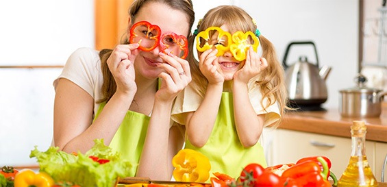 Madre e hija sosteniendo dos rodajas de pimiento como si fueran gafas