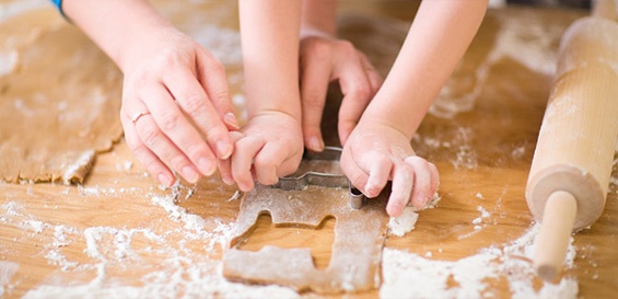 Madre e hija juntas cortando masa de galletas
